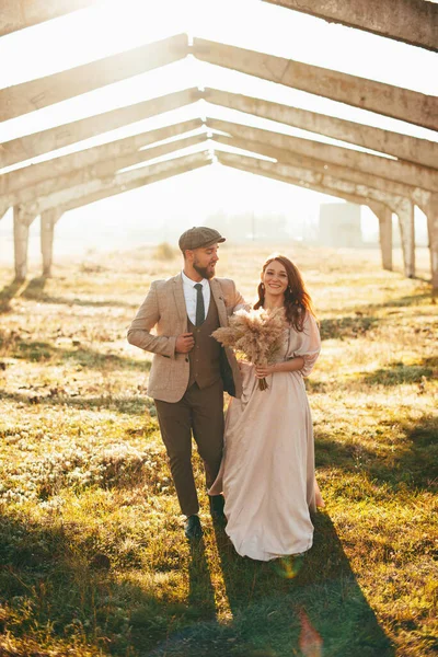 Neşeli, evli bir çift damat ve koca gün batımında birlikte yürüyorlar.