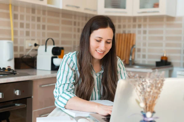 Jovem alegre em casual trabalhando em casa no laptop — Fotografia de Stock