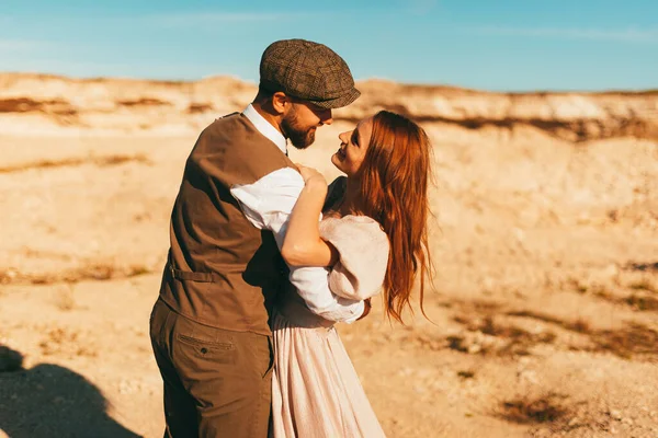 Joven pareja feliz mirando y sonriendo el uno al otro, al aire libre en el desierto. —  Fotos de Stock