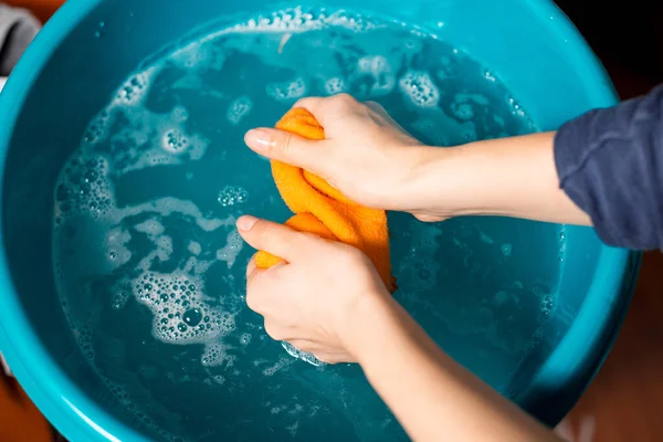 As mãos das mulheres estão lavando um pano de limpeza em um lavatório. — Fotografia de Stock