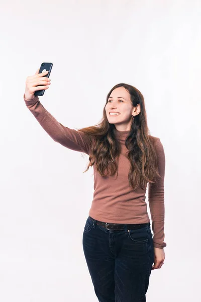 Foto de jovem tomando selfie sobre parede branca — Fotografia de Stock