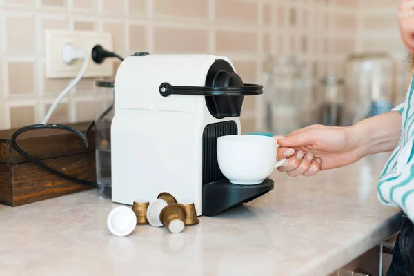 Közelkép kép nő főzés kávé kapszula gép a konyhában — Stock Fotó