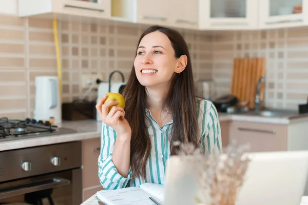 Foto de una mujer joven comiendo una manzana en pausa de trabajo desde casa — Foto de Stock