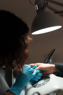 Güzellik salonunda manikür yapan bir kadın.