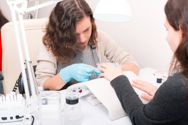 Güzellik salonunda manikür yapan bir kadın.