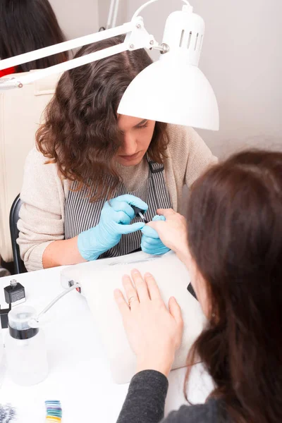 Mujer haciendo tratamiento de manicura en el salón de spa, uñas de belleza — Foto de Stock