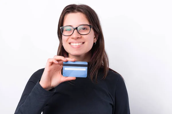 Gözlüklü ve mavi bankamatik kartı gösteren hoş bir genç kadın. — Stok fotoğraf