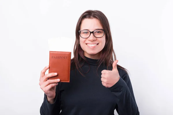 Retrato de mujer joven mostrando el pulgar hacia arriba y con pasaporte y boletos — Foto de Stock