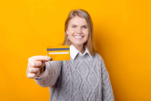 Foco seletivo no cartão de crédito, sorrindo jovem mostrando seu cartão — Fotografia de Stock