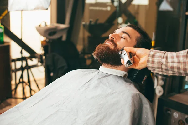 Foto de homem barbudo na barbearia fazendo corte de cabelo barba limpa — Fotografia de Stock