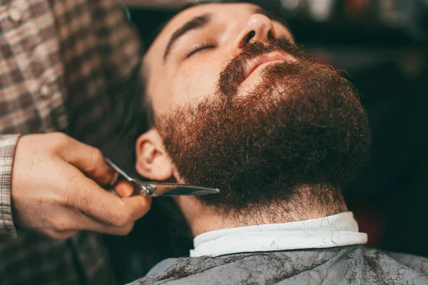 Foco seletivo de barbeiro fazendo corte de cabelo barba com tesoura — Fotografia de Stock
