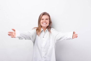 Photo of charming cute young woman making HUG gesture over white background