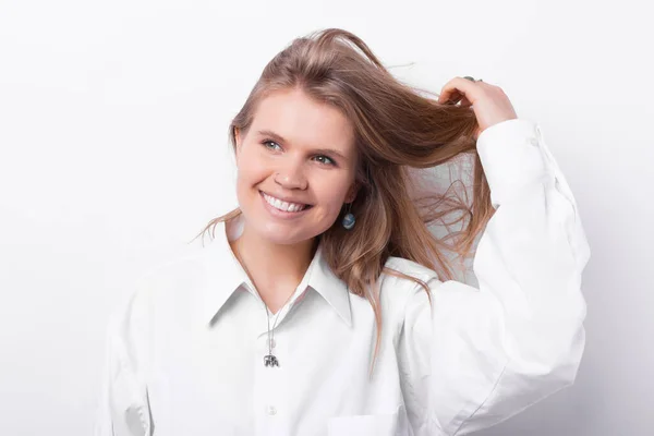 Retrato de linda mujer joven en camisa blanca con la mano en el pelo, buen champú — Foto de Stock