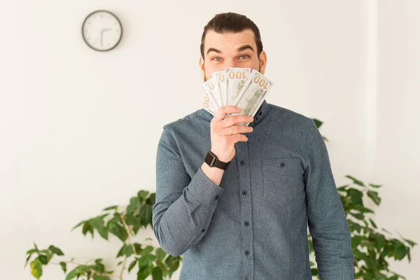 Photo of office worker man showing banknotes over office background — Stock Photo, Image