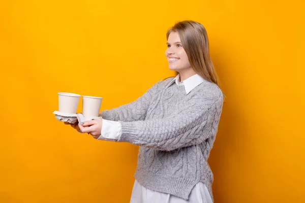 Fotografie de femeie tânără veselă care dă câteva cești de cafea pentru a merge — Fotografie, imagine de stoc