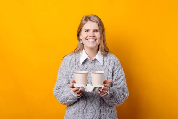 Фото щасливої жінки, що тримає чашки кави, щоб перейти на жовтий фон — стокове фото