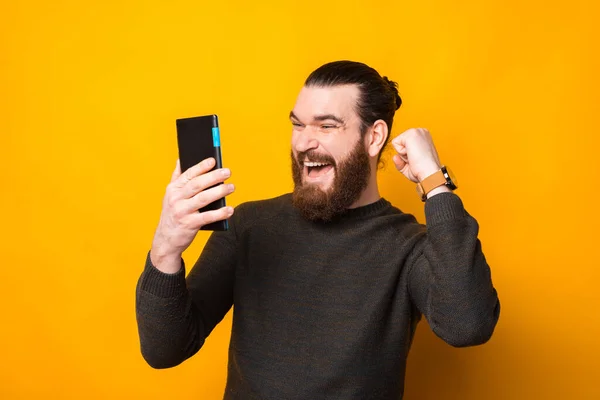 Homem hipster barbudo incrível olhando para tablet e celebrando o sucesso — Fotografia de Stock