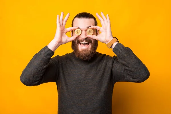 Photo of amazed bearded man holding bit coin over eyes — Stock Fotó