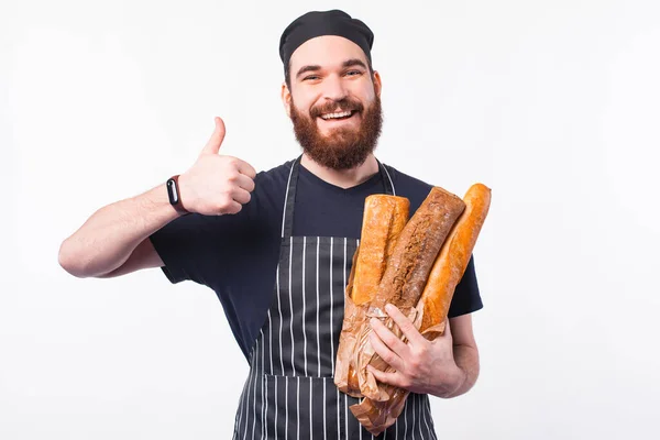 Foto f feliz chef homem segurando pão cozido fresco e mostrando o polegar para cima — Fotografia de Stock