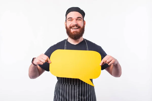 Фото улыбающегося молодого шеф-повара, держащего пустой пузырь речи — стоковое фото