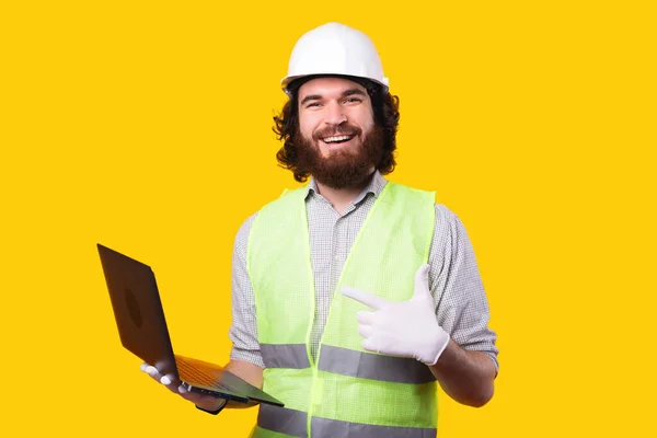 Foto del arquitecto sonriente apuntando a su nuevo portátil — Foto de Stock