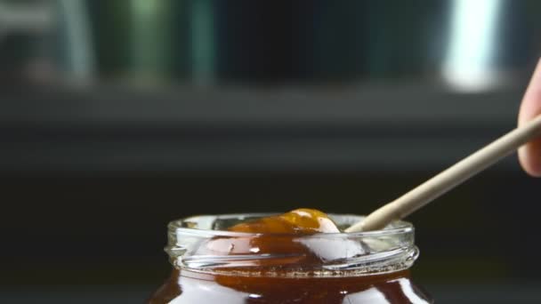 Primer plano de las imágenes con enfoque selectivo de la miel fresca sabrosa en un frasco — Vídeo de stock
