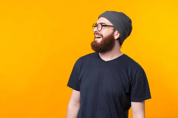 Ein Seitenprofil-Porträt eines bärtigen Mannes mit Brille, der wegschaut und weglächelt — Stockfoto
