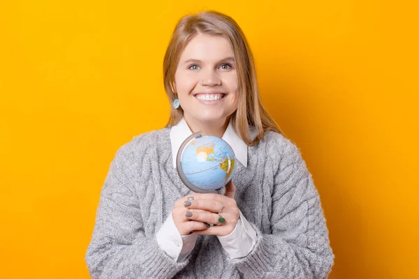 Una bonita foto de una mujer sosteniendo un globo con ambas manos y sonriendo está mirando a la cámara — Foto de Stock