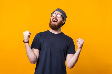 Sakallı genç bir hippi iki elini de havaya kaldırarak mutluluk çığlıkları atıyor.