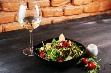 Güzel bir salata ve bir bardak şarap fotoğrafı.