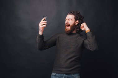 Genç sakallı bir adam kazandığı için heyecandan bağırıyor.