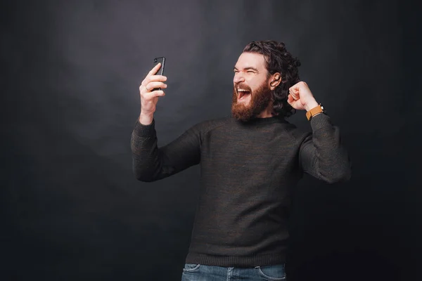 Un joven barbudo grita de emoción porque ganó. — Foto de Stock