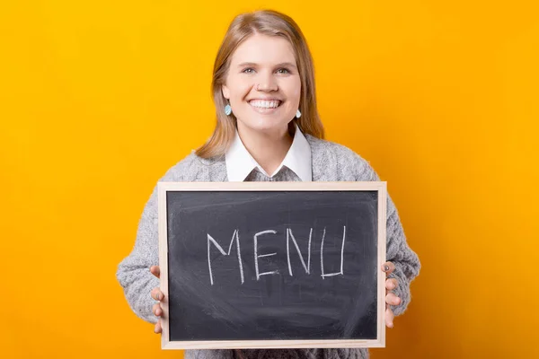 Photo of a woman holding a blackboard with the word menu written on it — Stock Photo, Image