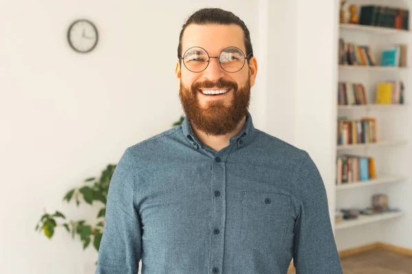 Un bel ritratto di un giovane barbuto in un ufficio sorride alla telecamera — Foto Stock