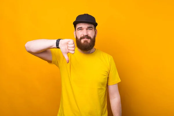 Ein bärtiger Mann zeigt das Ablehnungsschild in der Nähe einer gelben Wand, die unsicher ist — Stockfoto