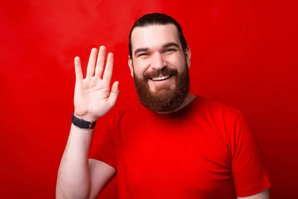 Photographie d'un homme agitant la main à la caméra et souriant comme un bonjour — Photo