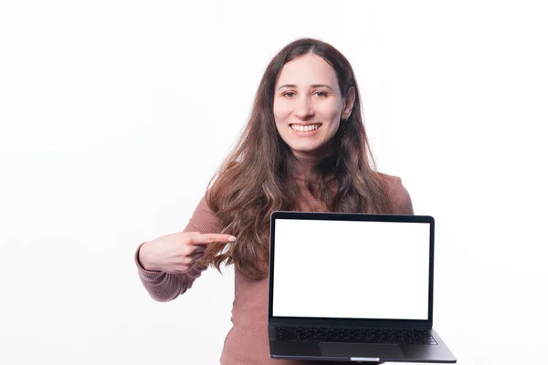 Giovane donna allegra in casual che punta lo schermo vuoto sul computer portatile e sorridente — Foto Stock