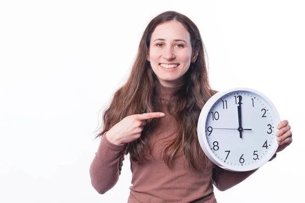 Foto di allegra giovane donna che indica orologio rotondo — Foto Stock