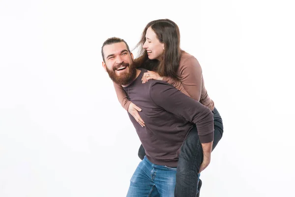 Foto av glada unga par att ha roligt och omfamna över vit bakgrund — Stockfoto