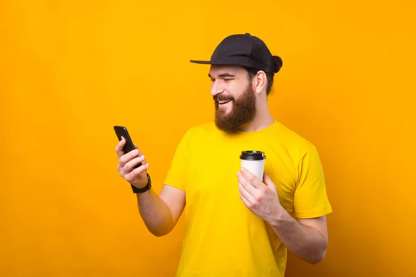 La foto del hombre feliz descansando del trabajo tomando el café y usando el teléfono — Foto de Stock
