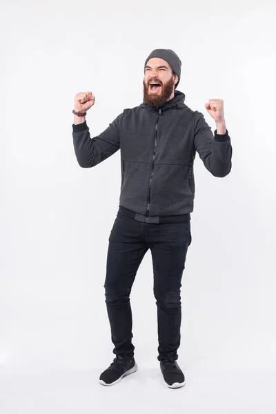 Full length φωτογραφία του γενειοφόρου hipster άνθρωπος γιορτάζει πάνω από λευκό φόντο — Φωτογραφία Αρχείου