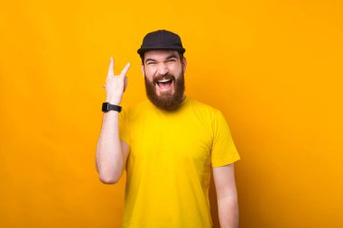 Taş İşareti gösteren genç ve çekici sakallı adamın portresi.