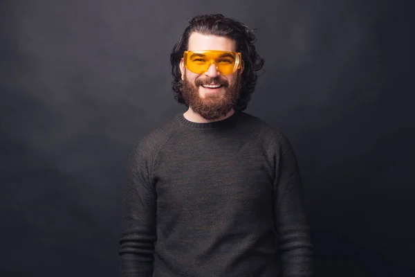 Portrait d'un bel homme barbu sur fond noir portant de grandes lunettes jaunes — Photo