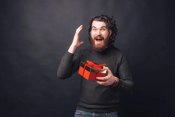Πορτρέτο του έκπληκτος γενειοφόρος άνδρας κρατώντας ένα κουτί δώρου — Φωτογραφία Αρχείου