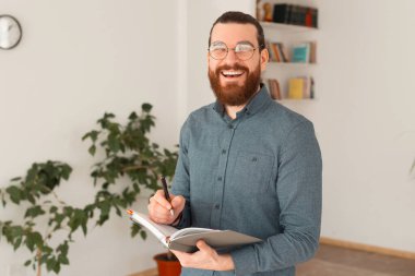 Ofiste geçirmeyi planlayan gülümseyen sakallı adamın portresi.