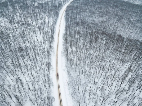 Όμορφη γραφική φωτογραφία από drone πάνω από εκπληκτικό τοπίο χειμώνα με χιόνι πάνω από το δάσος και το δρόμο — Φωτογραφία Αρχείου