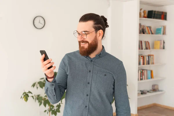 Photo de l'homme barbu dans occasionnel en utilisant smartphone dans le bureau — Photo
