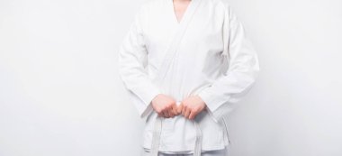 Beyaz arka planda tekvando üniformalı bir adamın yakın plan fotoğrafı.