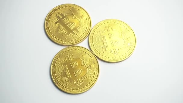 Rotating video of golden bitcoins on white background — Stock Video