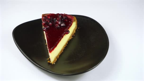 Περιστρεφόμενο βίντεο από νόστιμο cheesecake φρούτων στο πιάτο πάνω από λευκό φόντο — Αρχείο Βίντεο